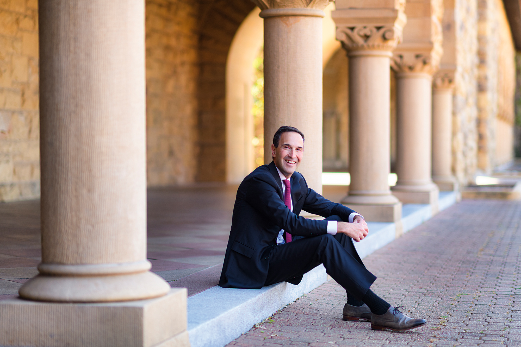 Jon Levin sitting in the Quad surrounded by columns