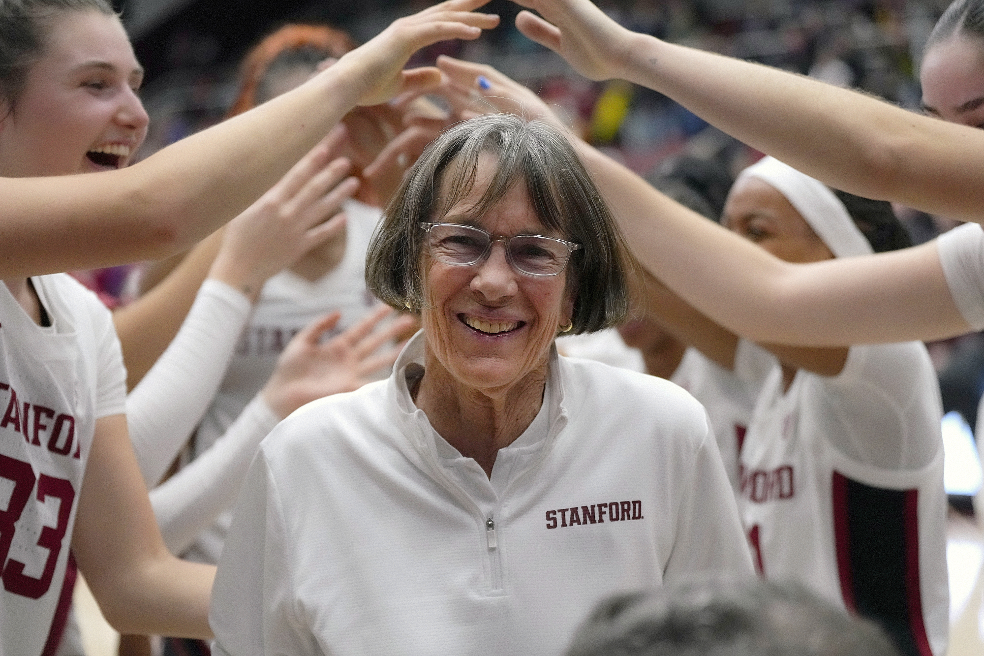 Tara VanDerveer surrounded by players.