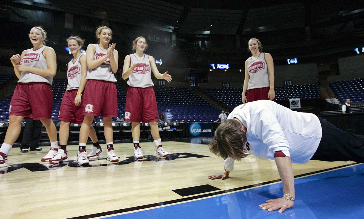 VanDerveer doing pushups as players watch.